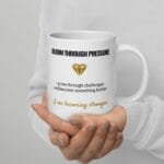 White ceramic Bloom Through Pressure affirmation mug, 20 oz, shown with the handle on the right